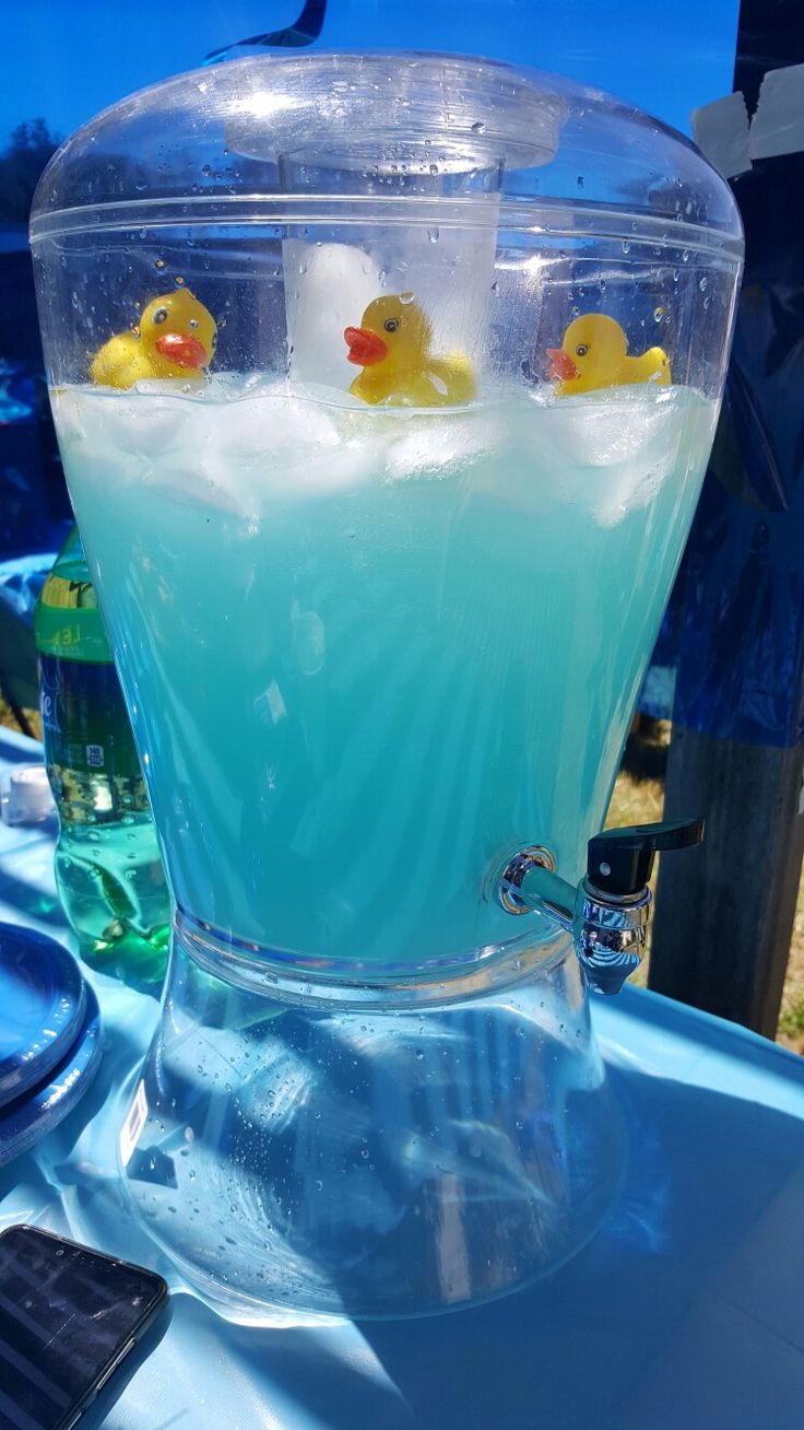 there are rubber ducks floating in the blue liquid that is filled with ice and water