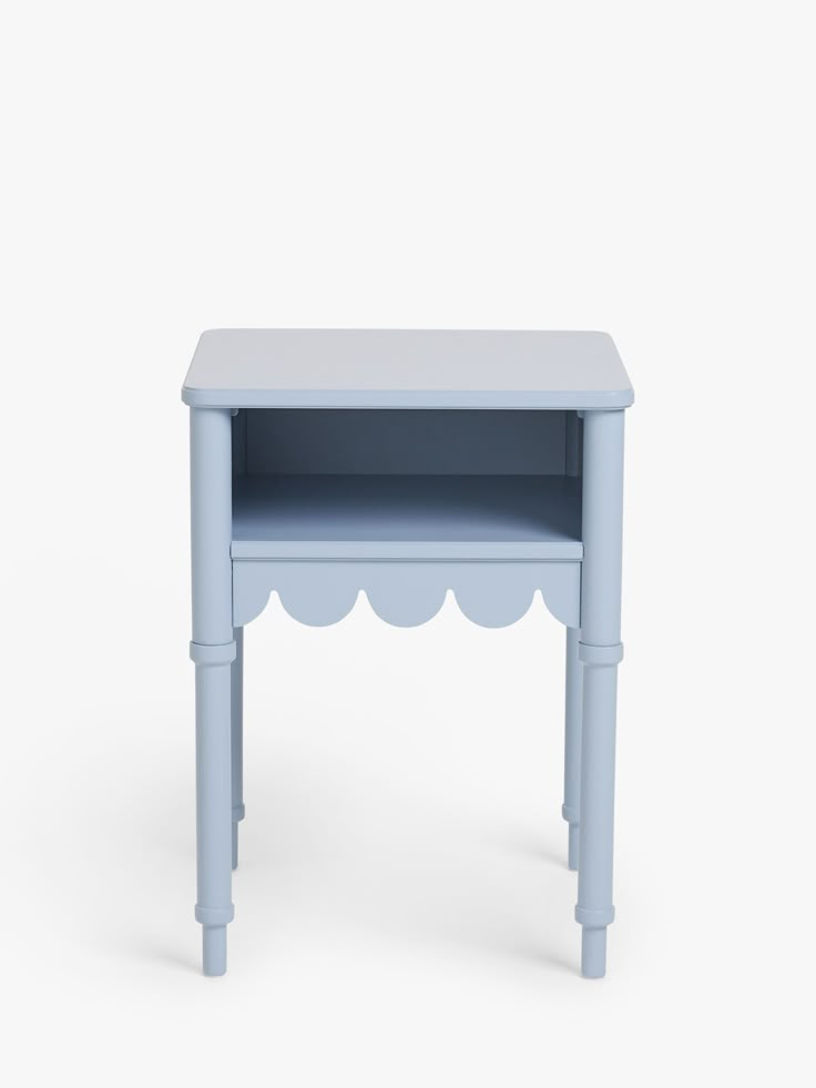 a small blue table with scalloped legs and a shelf on one side, against a white background