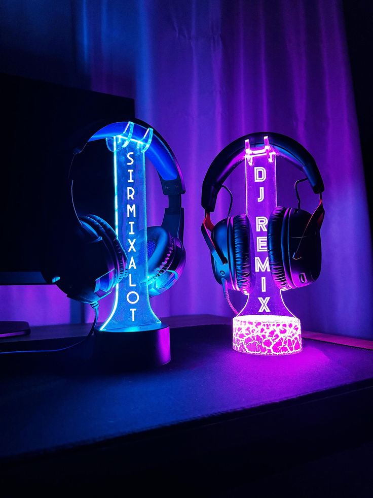 two headphones sitting next to each other in front of a computer monitor and keyboard