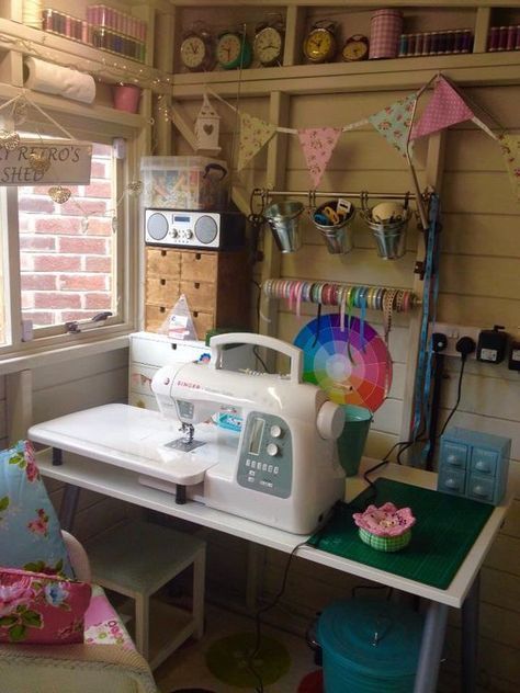 a sewing machine sitting on top of a white table next to a chair and window