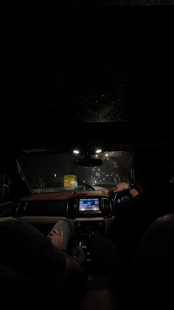 the interior of a car at night with its lights on and people sitting in it