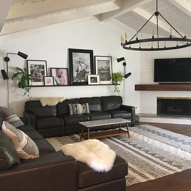 a living room filled with furniture and a flat screen tv mounted on the wall above a fireplace