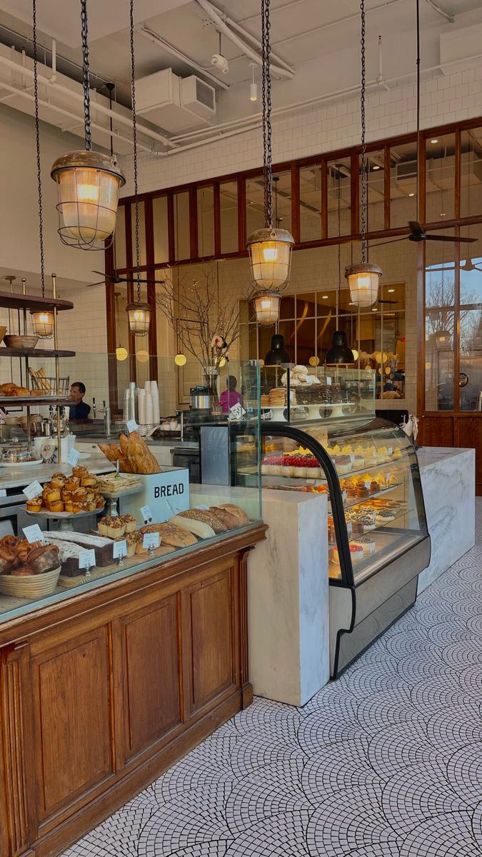 a bakery with lots of food on display in the front counter and behind it are hanging lights