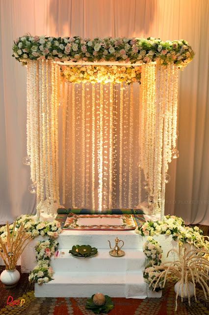 a decorated stage with white flowers and greenery