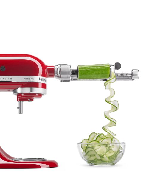 an image of a red food processor being used to make cucumber slices in a bowl