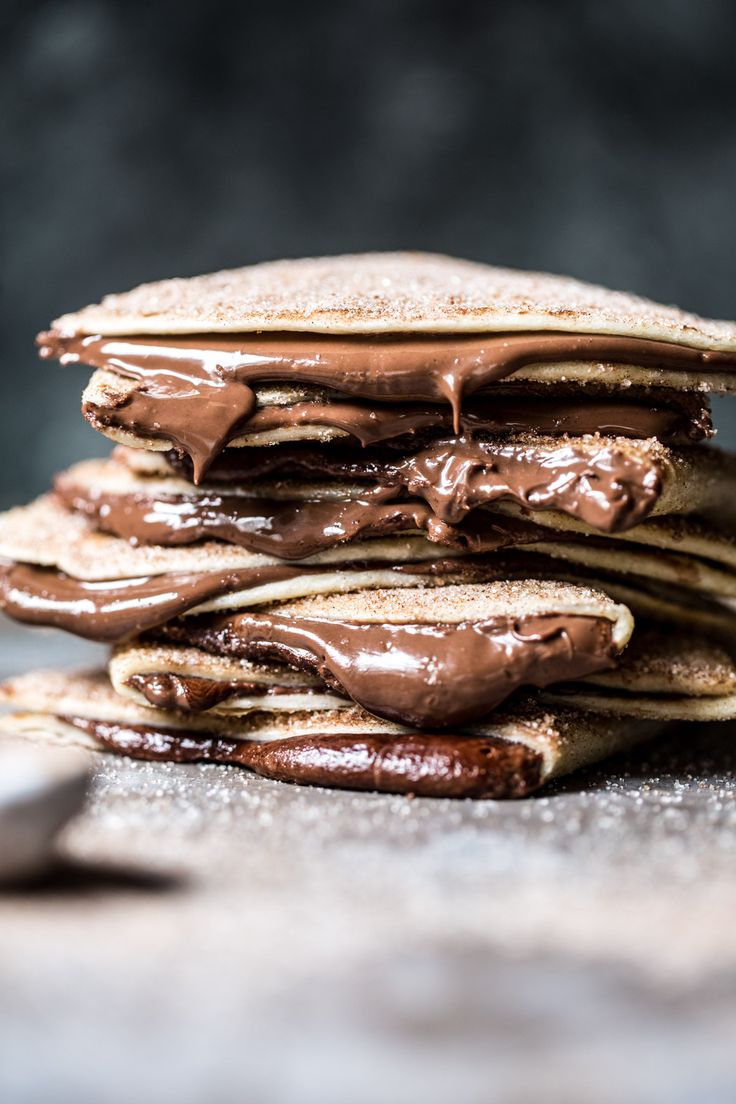 a stack of chocolate pancakes sitting on top of a wooden table