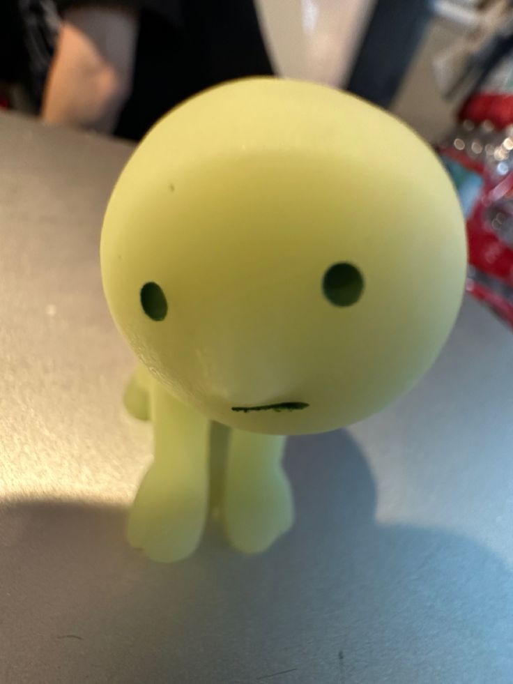 a small yellow toy sitting on top of a table