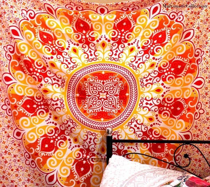 an orange and red wall hanging over a bed