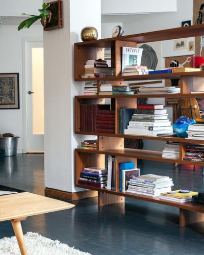 a living room filled with lots of books and furniture