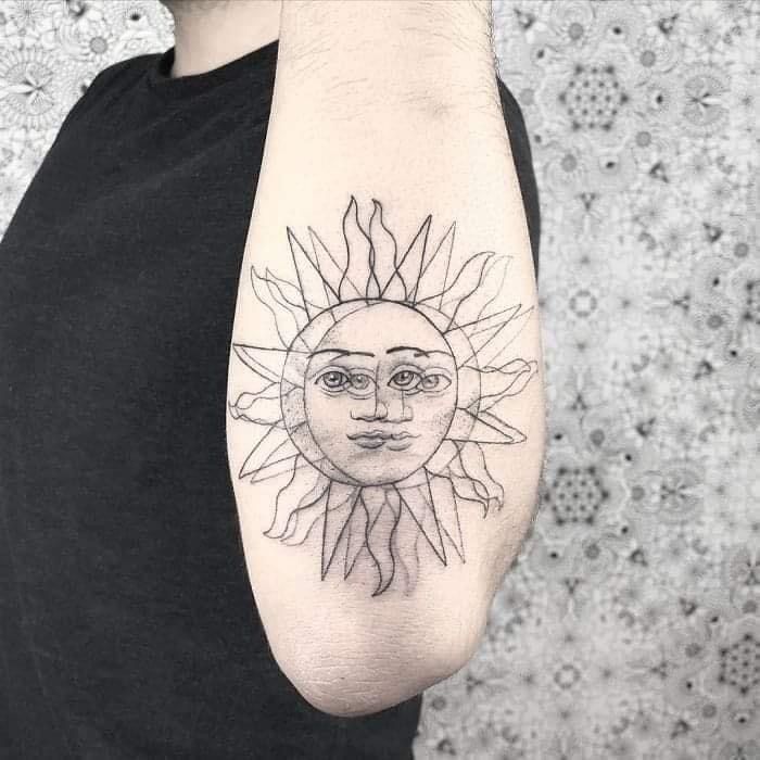 a man with a sun tattoo on his arm