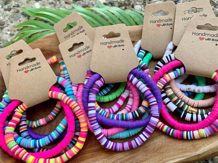 several different colored bracelets sitting on top of a wooden table