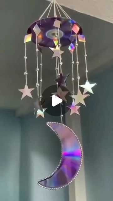 a wind chime hanging from the ceiling with stars and moon design on it's side