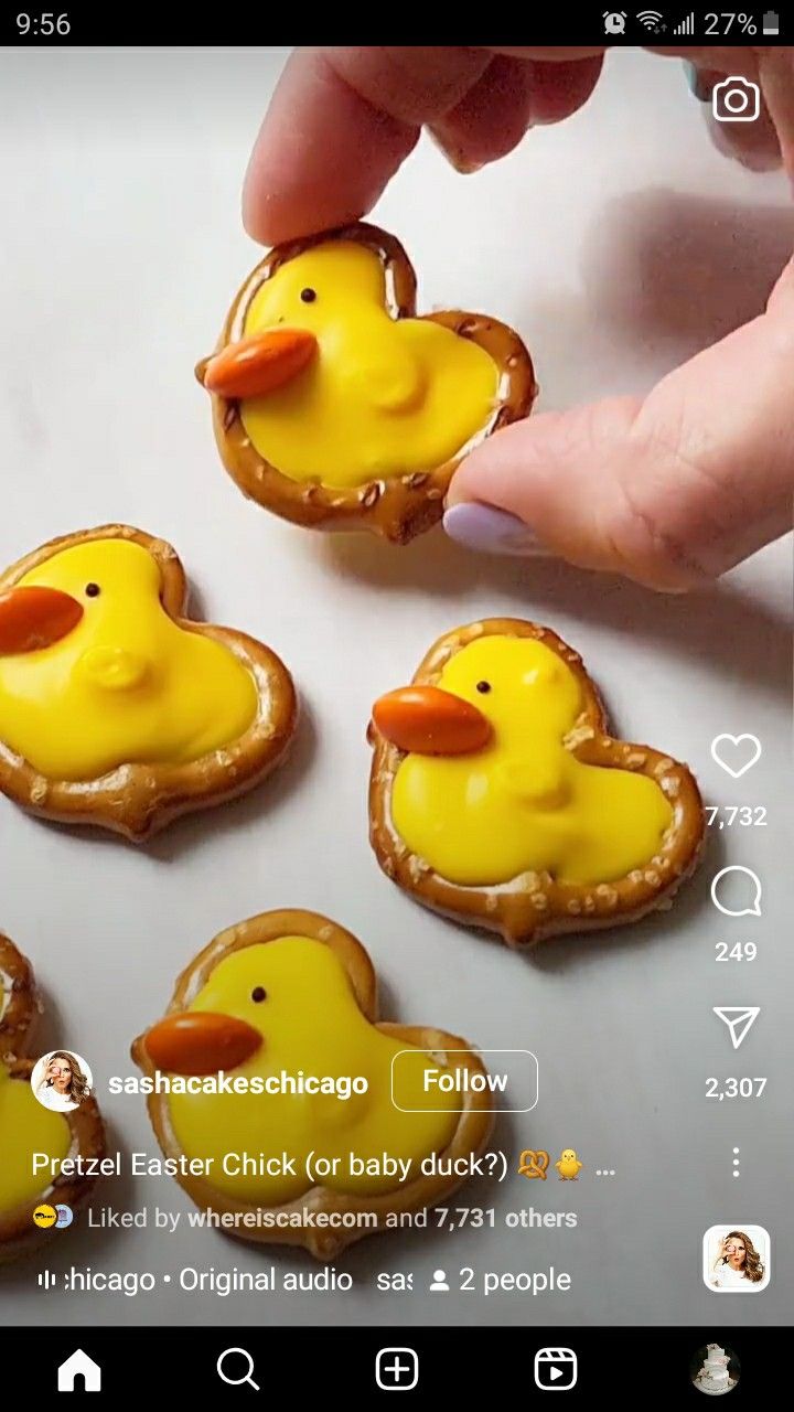 a person is holding some cookies with yellow icing on them and there are little rubber ducks in the middle