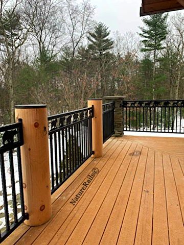 a wooden deck with railings and snow on the ground