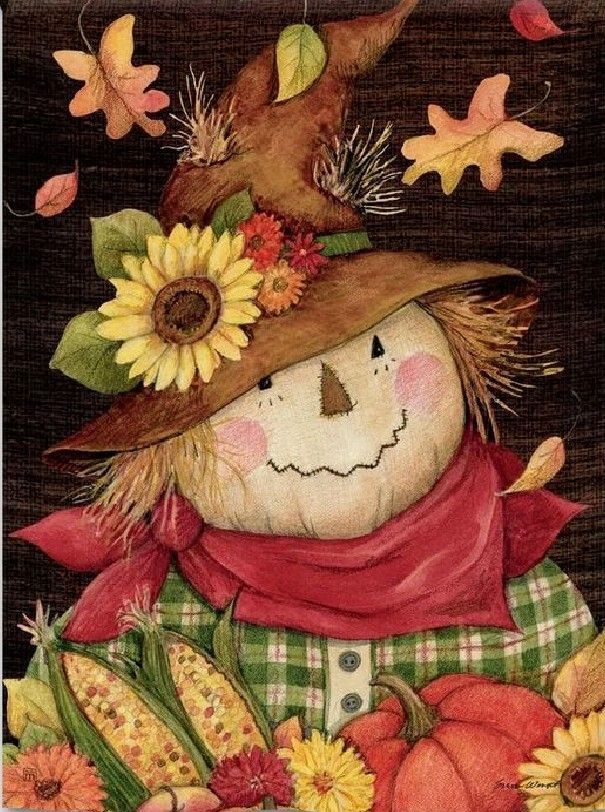 a scarecrow with sunflowers and corn on it's head, surrounded by fall leaves