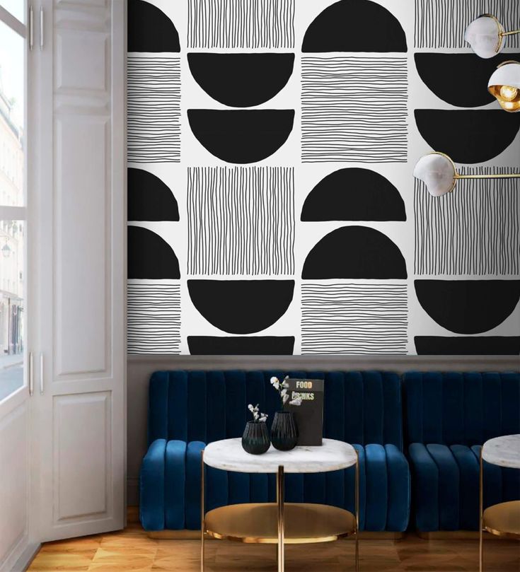 a living room with black and white wallpaper, two blue couches and a coffee table