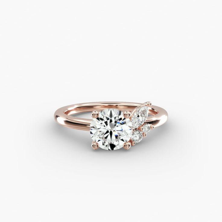 a rose gold engagement ring with three stones on the side and an oval diamond in the center