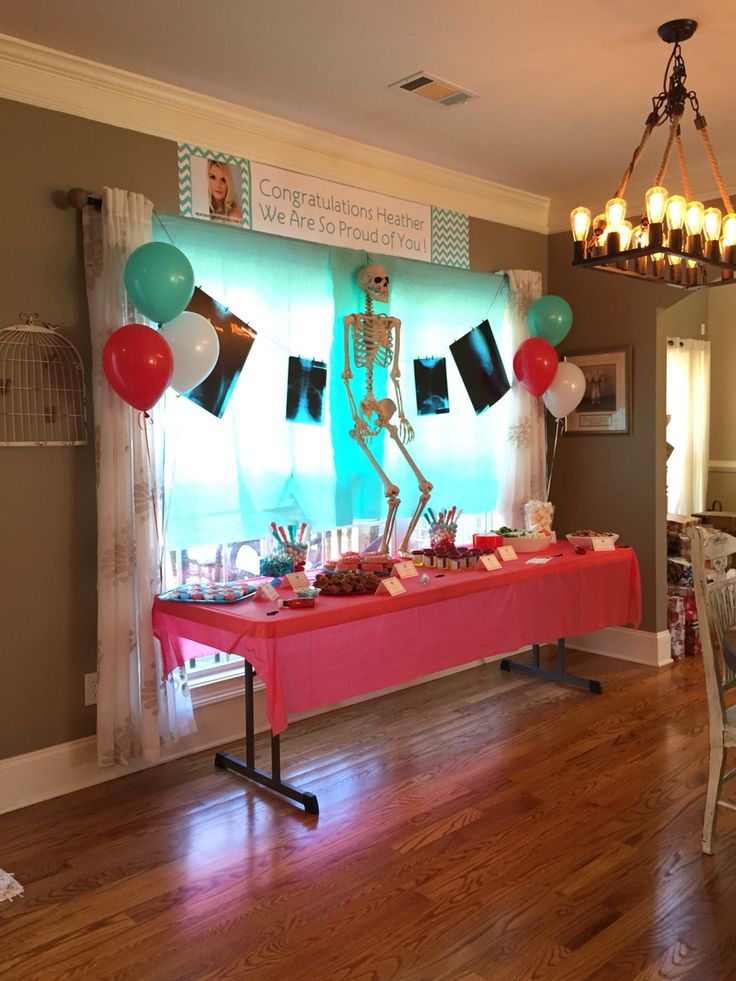 a table that has some balloons on it and a skeleton in the middle with other decorations