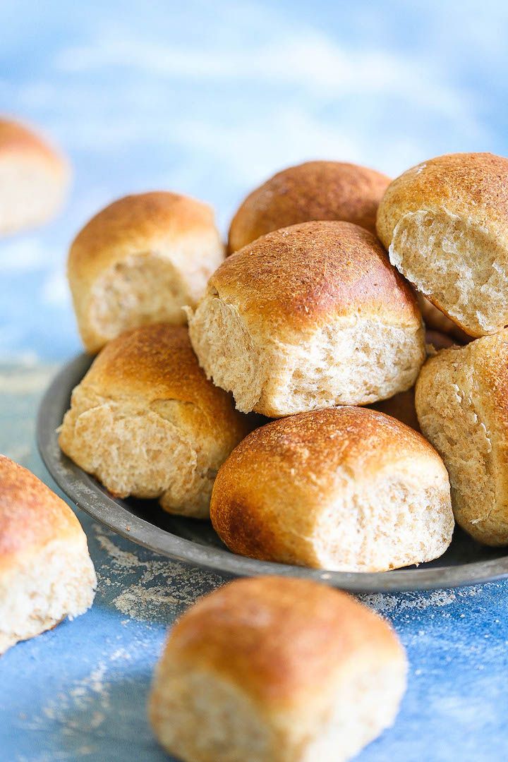 a plate filled with rolls on top of a blue table