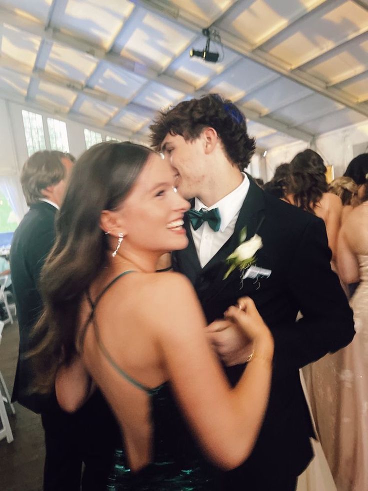 a man and woman in formal wear standing next to each other on a dance floor