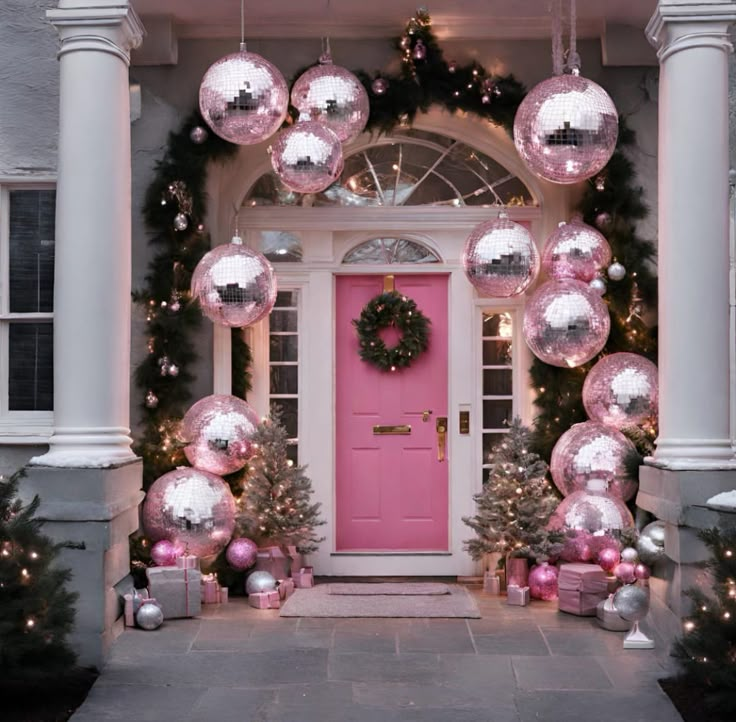 a pink door surrounded by christmas decorations