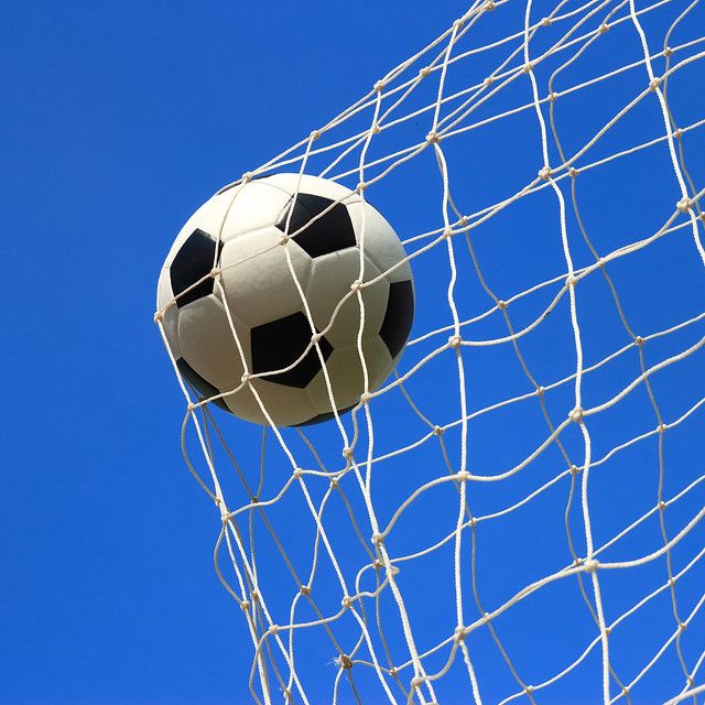 a soccer ball is stuck in the net