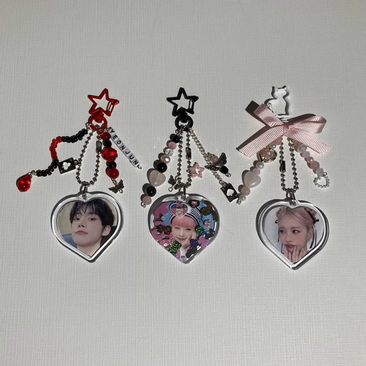 three heart shaped key chains with pictures on them