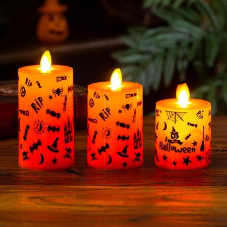 three lit candles sitting on top of a wooden table