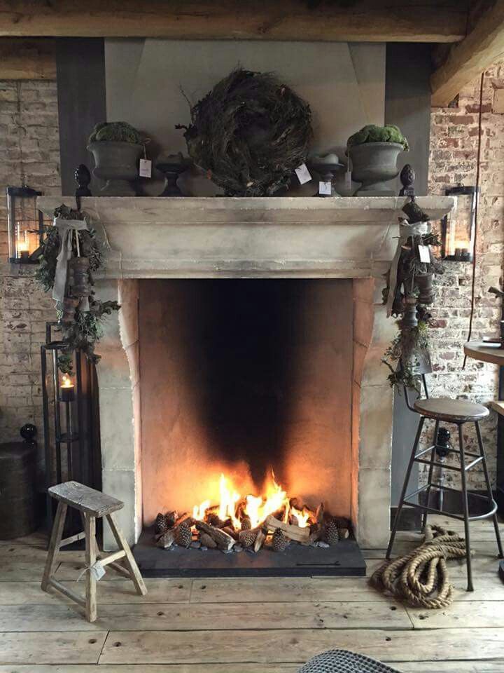 a fireplace is lit with candles and wreaths