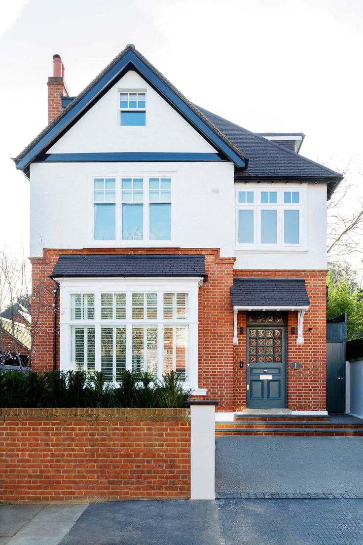 a large brick house with white windows and blue trim on the front door is shown