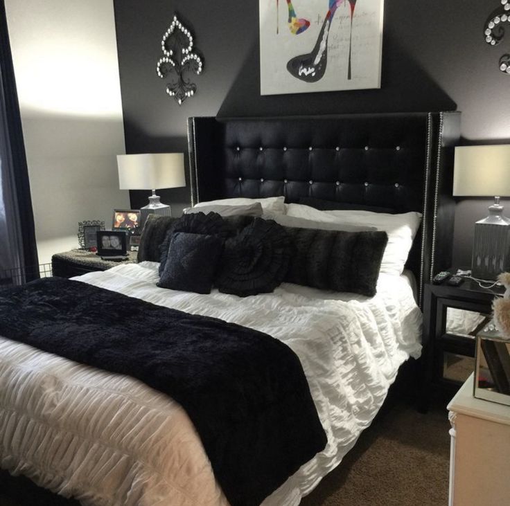 a black and white bedroom with high heels on the headboard