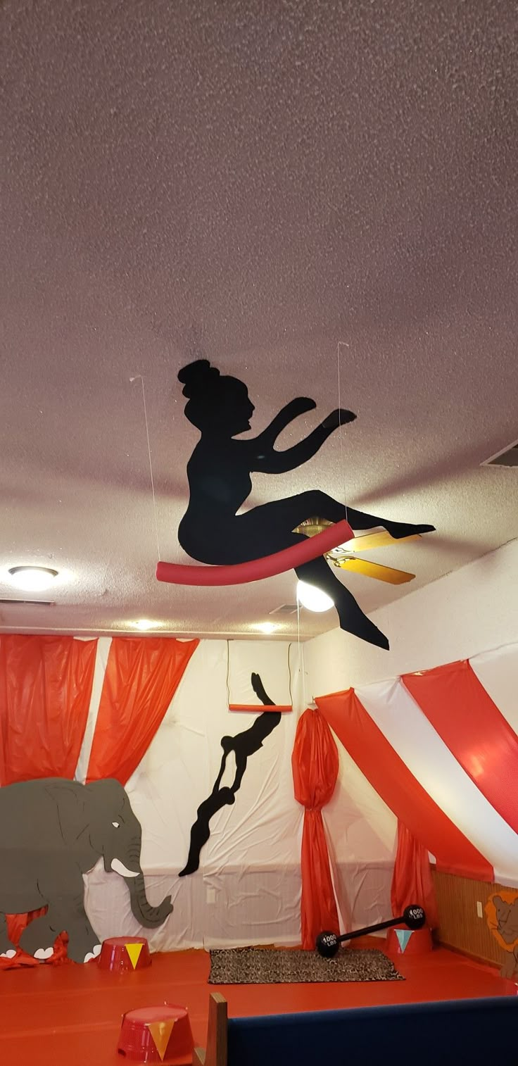 an indoor play area with various decorations and animals on the ceiling, including a circus tent