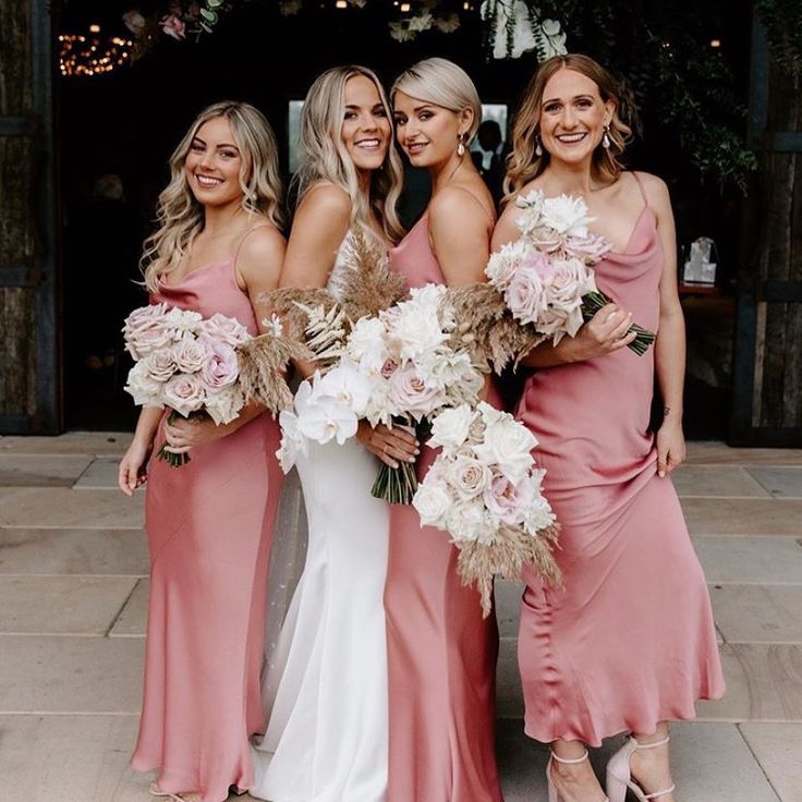 the bridesmaids are all wearing pink dresses and holding bouquets in their hands