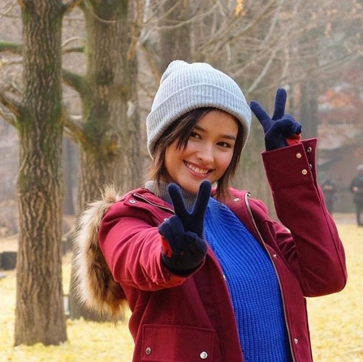 a woman in a park giving the peace sign