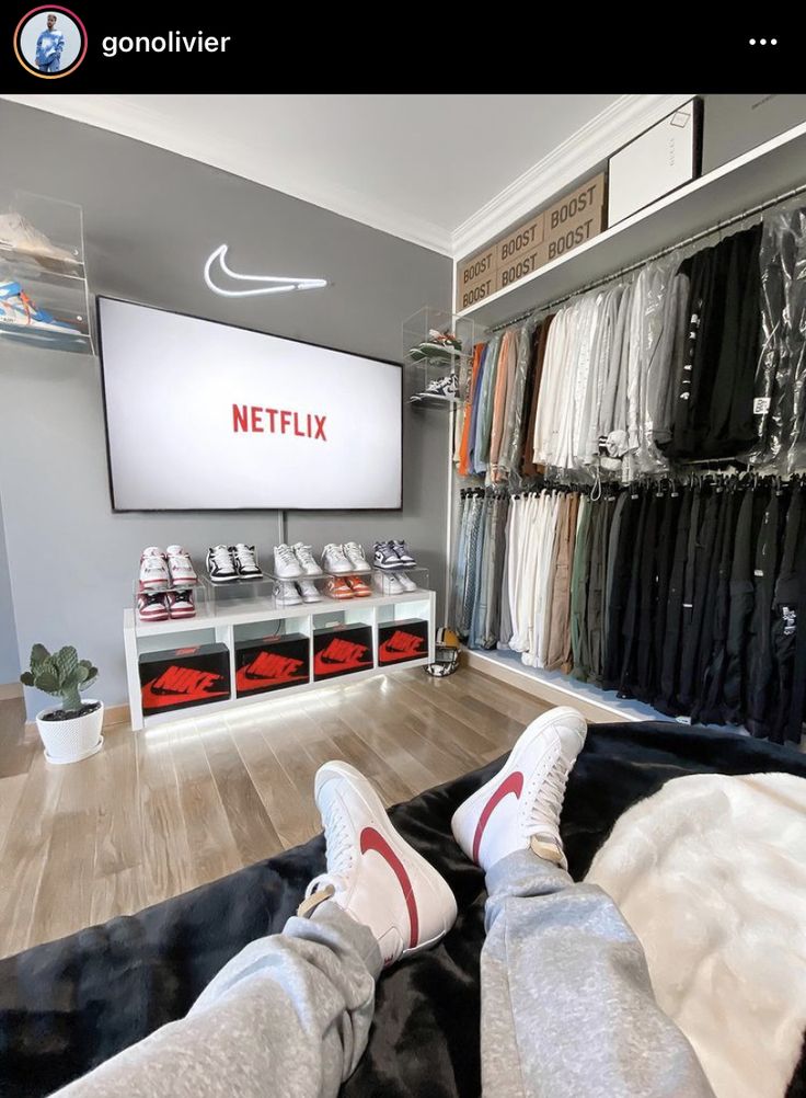 a person laying on the floor in front of a large screen tv that is displaying clothes