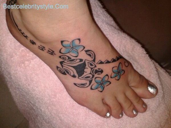 a woman's foot with butterfly tattoos on it