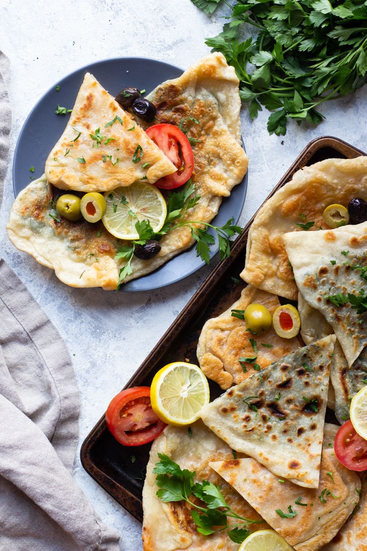 two plates filled with pita bread and vegetables