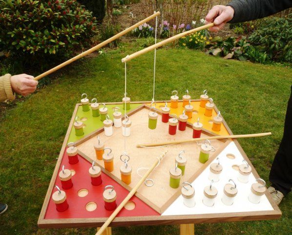 two people are playing an outdoor game in the grass with drinks on it and sticks