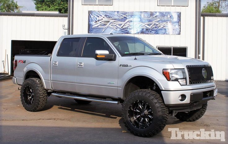 a silver truck parked in front of a building