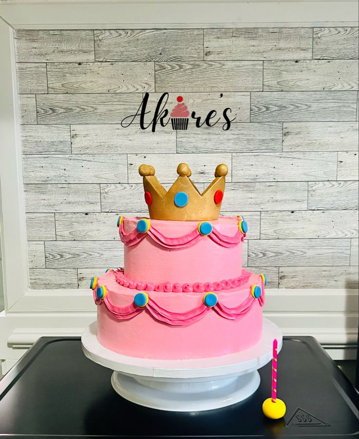 there is a pink cake with a crown on top