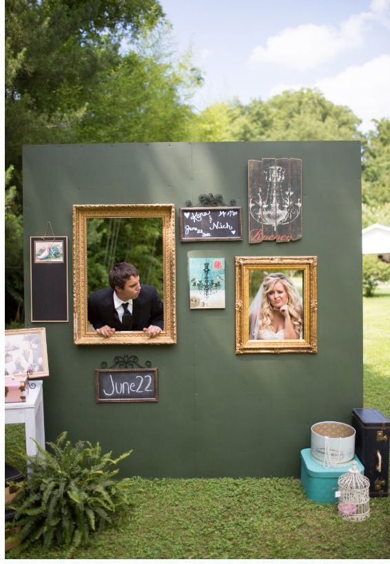 a man and woman standing in front of a green wall with pictures on it