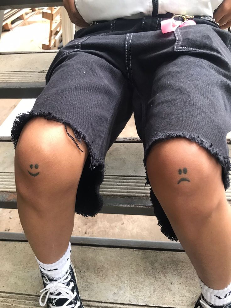 the legs and knees of a person with small tattoos on their ankles, sitting on some steps