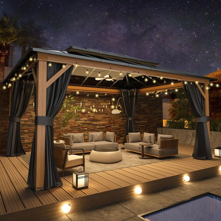 an outdoor living area with couches and lights on the ceiling, under a night sky filled with stars