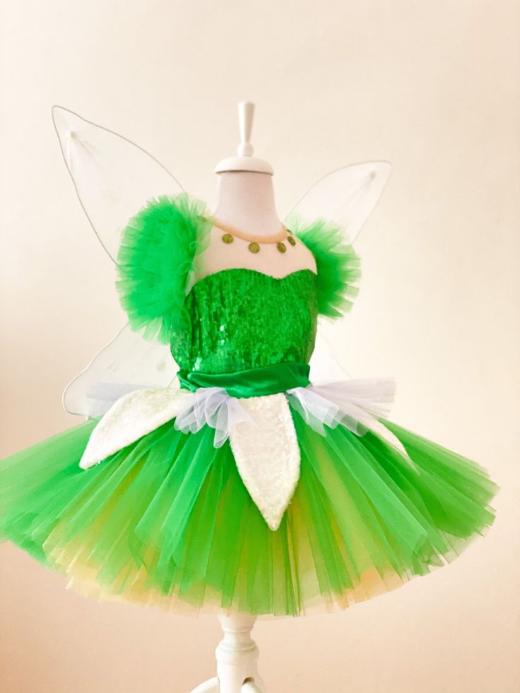 a green and white fairy costume on a mannequin headdress with gold accents