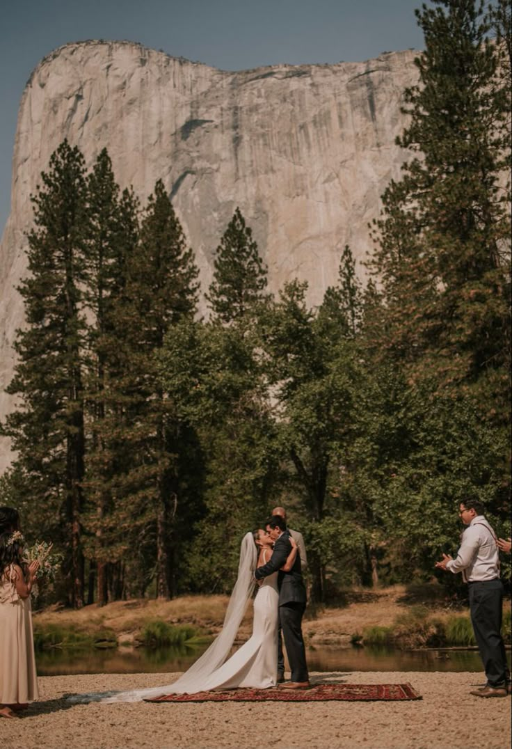 a couple getting married in front of a mountain