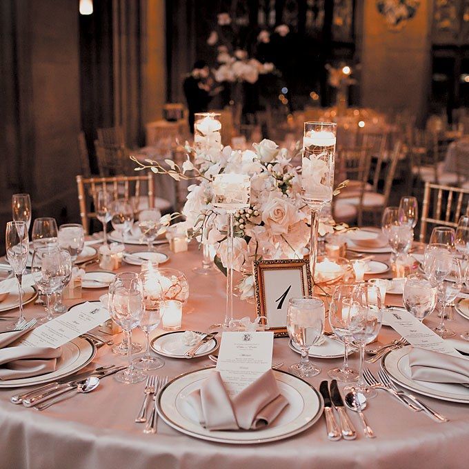 the table is set with white plates and silverware for an elegant wedding reception or special event