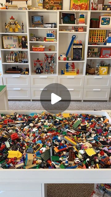 a bed with lots of legos on it in a room filled with toys and bookshelves