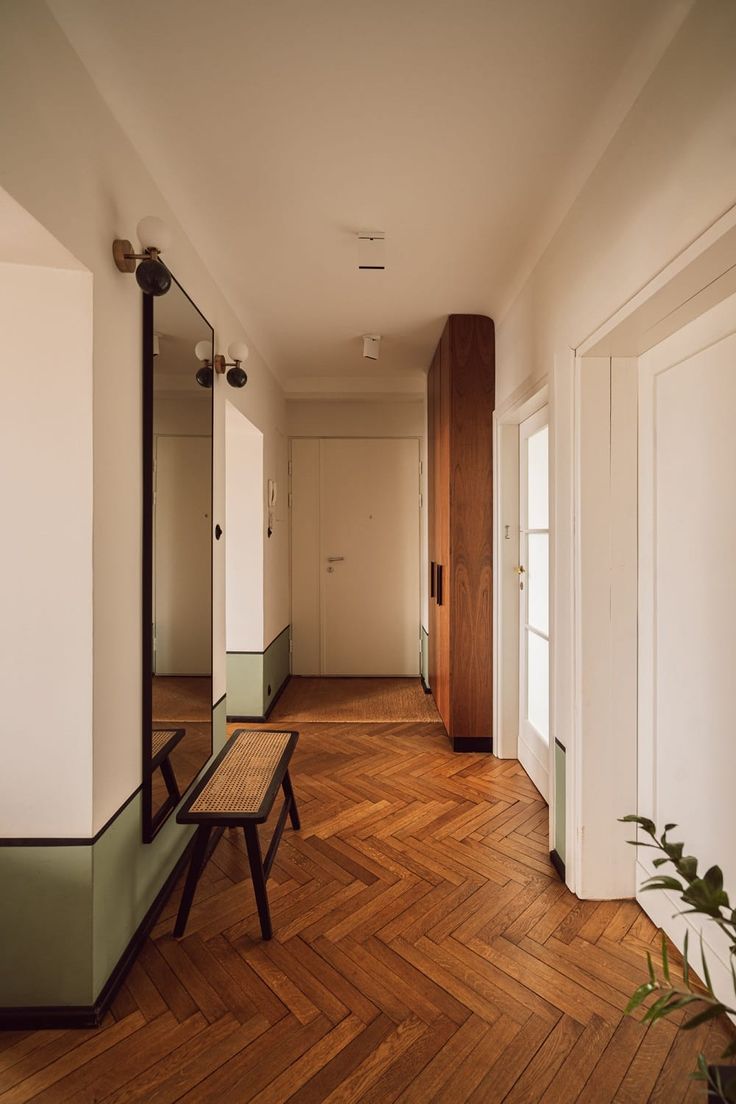 an empty room with wooden floors and mirrors on the wall, along with two benches