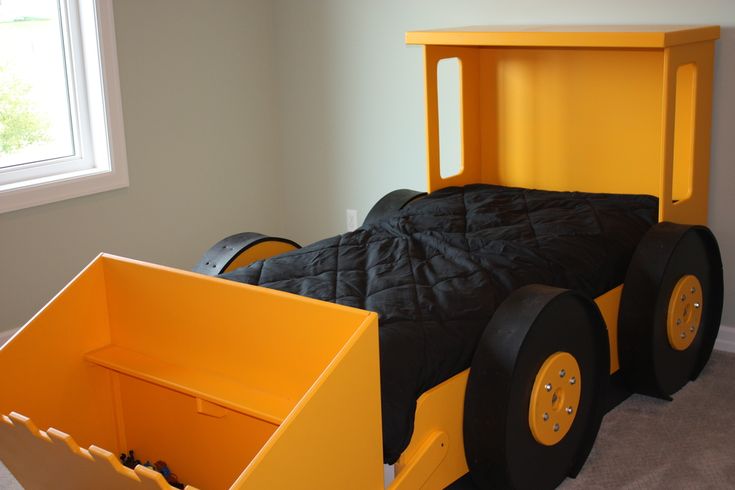 a child's bed made to look like a race car with black and yellow wheels