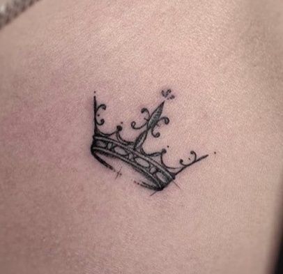 a small crown tattoo on the stomach